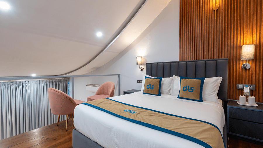 Spring Duplex Room at DLS Spring  Valley resort Dharamshala on the second story featuring a king bed table, chairs and a  bed lamp